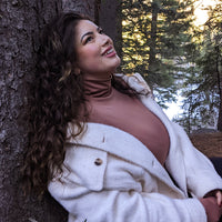 Woman Standing Next To A Tree Wearing A Copper Turtleneck