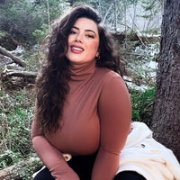 Woman Outside In The Woods Wearing A Copper Turtleneck