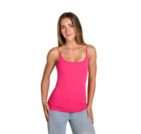 A woman modeling a fuchsia camisole with thin straps and a scoop neckline, paired with light blue jeans, against a solid white background.