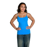 A woman modeling a turquoise camisole with thin straps and a scoop neckline, paired with blue jeans, against a solid white background.