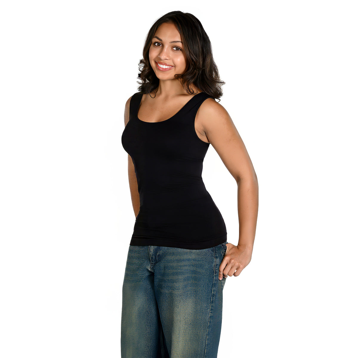 A woman modeling a black scoop-neck tank top with blue jeans, standing against a solid white background.