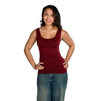 A woman modeling a sleeveless scoop-neck tank top in cranberry, paired with blue jeans, against a solid white background.