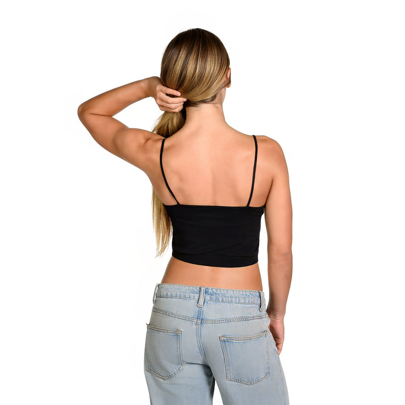 A woman shown from the back wearing a black spaghetti-strap bralette and light-wash blue jeans against a plain white background.