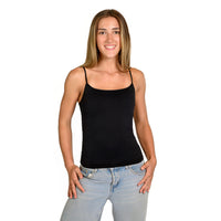A woman modeling a black spaghetti-strap petite camisole paired with light-wash blue jeans, standing against a solid white background.