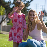 Woman outside wearing a  Baby Pink Basic Tank Top  with jeans standing with a young girl in a pink dress