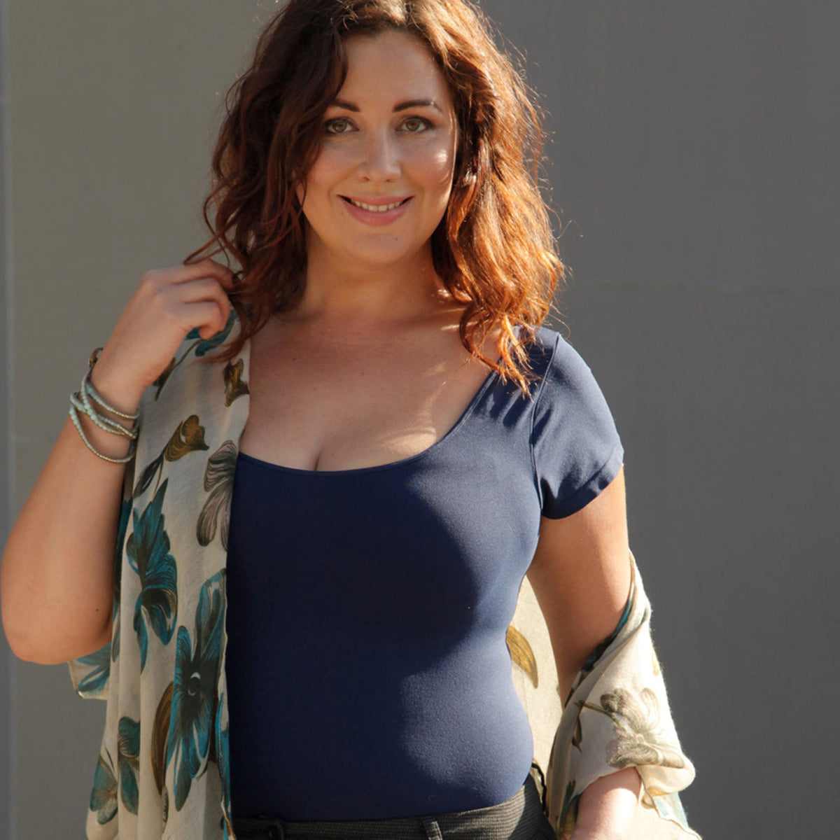 woman wearing a navy plus sized cap sleeve tee with floral kimono and bangle bracelets