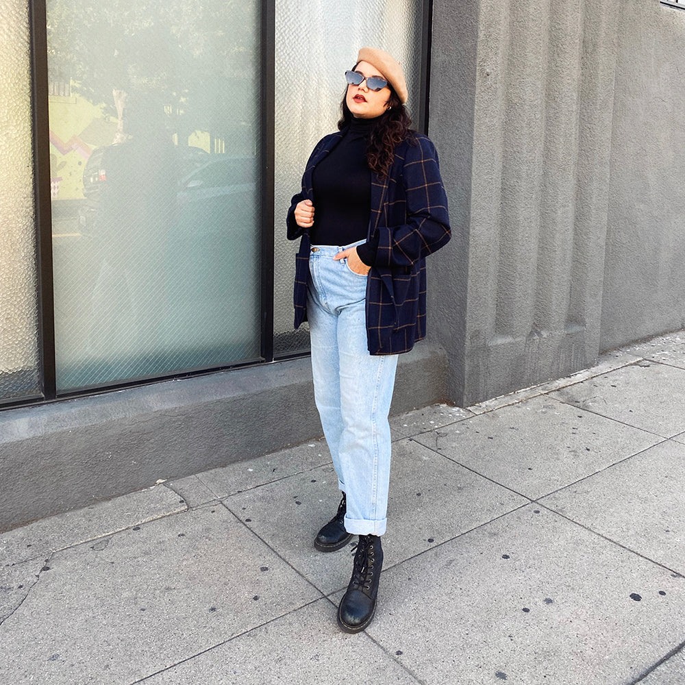 Woman Next To A Building With A Hand In Her Pocket Wearing A Black Turtleneck And Beret