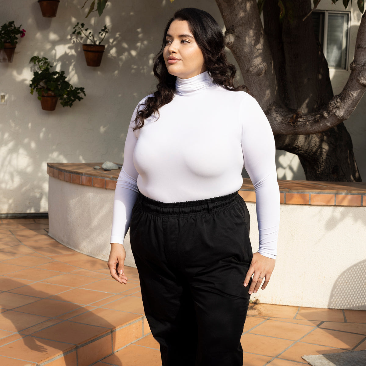 Woman Outside Wearing White Plus Size Turtleneck And Black Pants