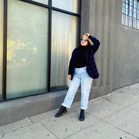Woman Next To A Building  Wearing A Black Turtleneck And Blazer And Jeans