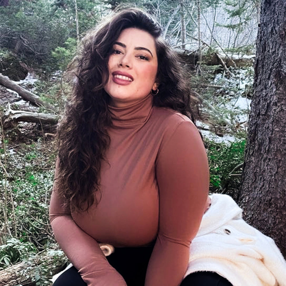 Woman Outside In The Woods Wearing A Copper Turtleneck